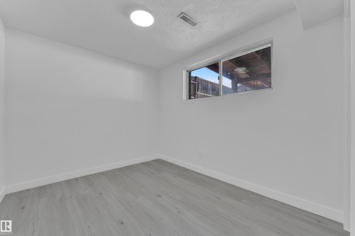 Spare room with baseboards and light wood-style floors - 8635 33 Avenue, Edmonton, AB - Indoor Photo Showing Other Room