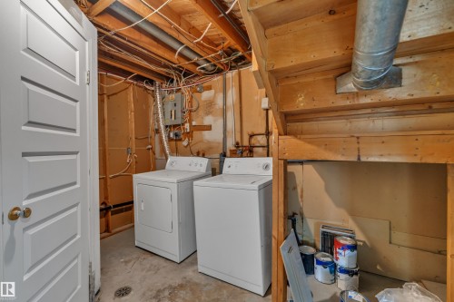 Laundry area with unfinished concrete floors, separate washer and dryer, and electric panel - 8635 33 Avenue, Edmonton, AB - Indoor Photo Showing Laundry Room