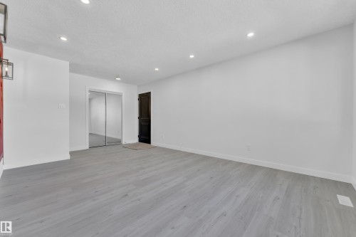 Spare room with light wood-style floors, a textured ceiling, and recessed lighting - 8635 33 Avenue, Edmonton, AB - Indoor Photo Showing Other Room