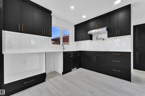 Kitchen featuring dark cabinets, modern cabinets, light stone countertops, and recessed lighting - 8635 33 Avenue, Edmonton, AB - Indoor Photo Showing Kitchen