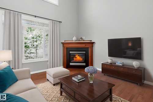 Living area with wood finished floors and a glass covered fireplace - 11546 11 Avenue, Edmonton, AB - Indoor Photo Showing Living Room With Fireplace