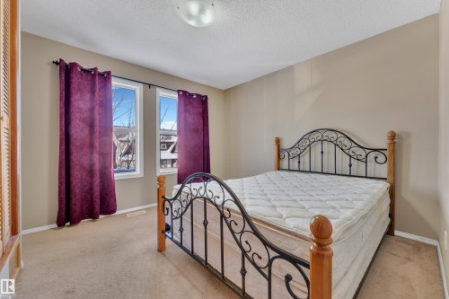 Bedroom with light carpet and a textured ceiling - 6017 213 Street, Edmonton, AB - Indoor Photo Showing Bedroom