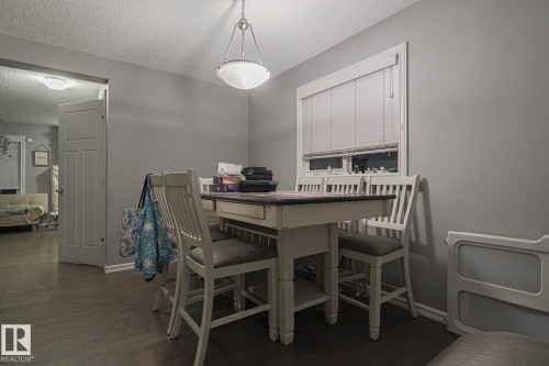 Dining room featuring dark wood-style floors and a textured ceiling - 21971 91 Avenue Nw, Edmonton, AB - Indoor