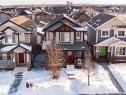 Craftsman-style house featuring a residential view, stone siding, covered porch, and a shingled roof - 21971 91 Avenue Nw, Edmonton, AB  - Outdoor With Facade 