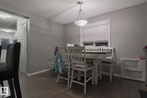 Dining area with a textured ceiling and dark wood finished floors - 21971 91 Avenue Nw, Edmonton, AB - Indoor Photo Showing Dining Room