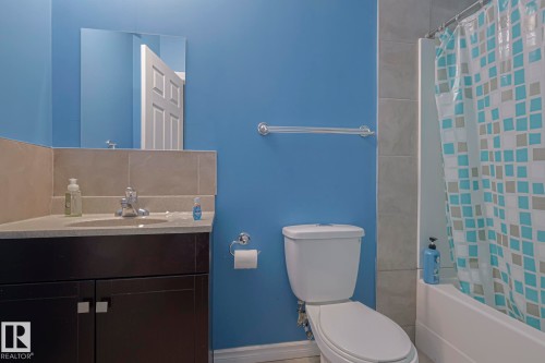 Bathroom featuring vanity, shower / tub combo with curtain, and backsplash - 21971 91 Avenue Nw, Edmonton, AB - Indoor Photo Showing Bathroom