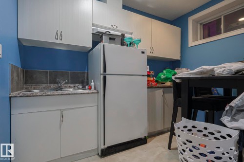 Kitchen featuring freestanding refrigerator, white cabinets, and dark countertops - 21971 91 Avenue Nw, Edmonton, AB - Indoor