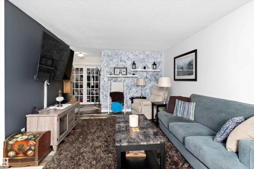 Living room with a textured ceiling and wood finished floors - # 3 13450 Fort Road, Edmonton, AB - Indoor Photo Showing Living Room