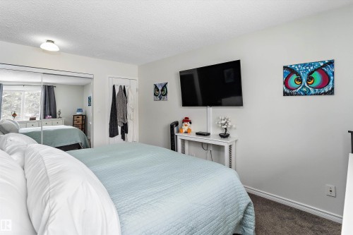 Bedroom featuring a textured ceiling and dark colored carpet - # 3 13450 Fort Road, Edmonton, AB - Indoor Photo Showing Bedroom