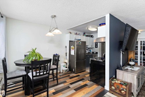 Dining area with a textured ceiling and light wood-style floors - # 3 13450 Fort Road, Edmonton, AB - Indoor Photo Showing Dining Room