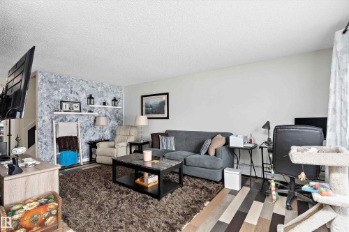 Living room featuring a textured ceiling and wood finished floors - # 3 13450 Fort Road, Edmonton, AB - Indoor Photo Showing Living Room