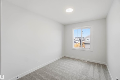 Unfurnished room featuring baseboards and light carpet - 19348 29 Avenue, Edmonton, AB - Indoor Photo Showing Other Room