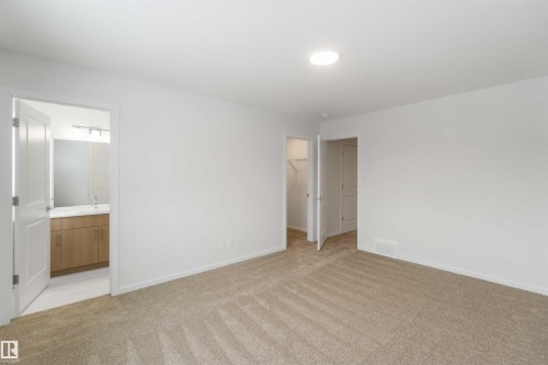 Unfurnished bedroom featuring a spacious closet, light carpet, and connected bathroom - 18912 28 Avenue, Edmonton, AB - Indoor Photo Showing Other Room