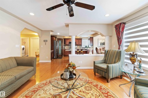 Living area featuring arched walkways, ceiling fan, light wood-style floors, and recessed lighting - 6116 53 Avenue, Beaumont, AB - Indoor Photo Showing Living Room