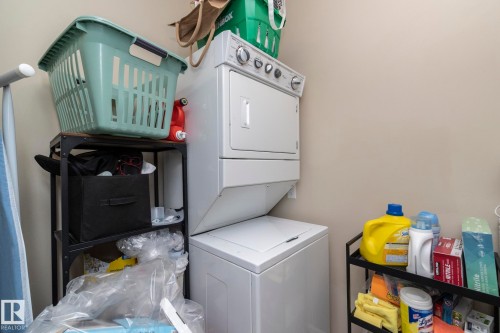 Laundry area featuring stacked washing machine and dryer - 416 263 Macewan Road, Edmonton, AB - Indoor Photo Showing Laundry Room