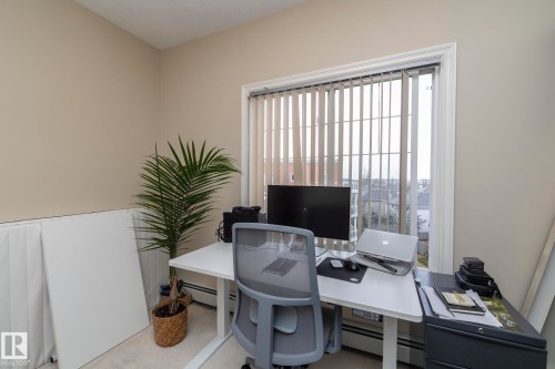 Office area featuring a baseboard radiator and light colored carpet - 416 263 Macewan Road, Edmonton, AB - Indoor Photo Showing Office