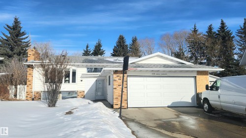 View of front of property featuring a garage, a shingled roof, brick siding, driveway, and a chimney - 115 Ekota Crescent, Edmonton, AB - Outdoor