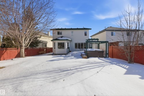 Snow covered back of property with a hot tub and a fenced backyard - 444 Breckenridge Lane Nw, Edmonton, AB - Outdoor