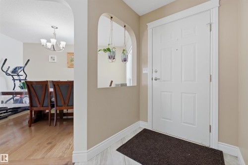 Foyer featuring arched walkways, a chandelier, and light wood-style floors - 444 Breckenridge Lane Nw, Edmonton, AB - Indoor Photo Showing Other Room