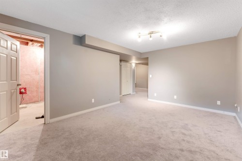 Empty room featuring light carpet and a textured ceiling - 1157 37 Avenue, Edmonton, AB - Indoor Photo Showing Other Room