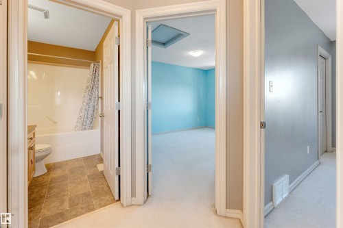 Corridor featuring light carpet and attic access - 1157 37 Avenue, Edmonton, AB - Indoor Photo Showing Bathroom