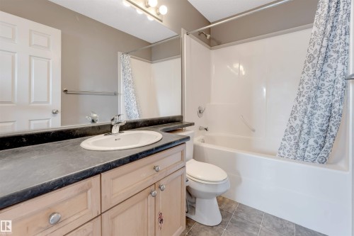Full bathroom with vanity, shower / tub combo, and light tile patterned flooring - 1157 37 Avenue, Edmonton, AB - Indoor Photo Showing Bathroom