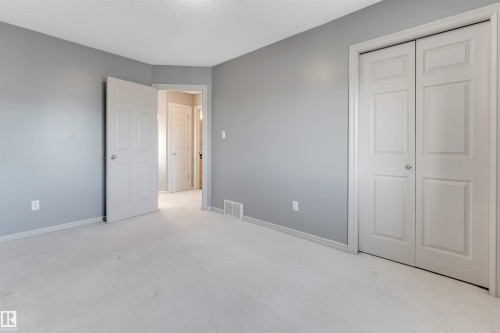Unfurnished bedroom with light colored carpet, a closet, and a textured ceiling - 1157 37 Avenue, Edmonton, AB - Indoor Photo Showing Other Room