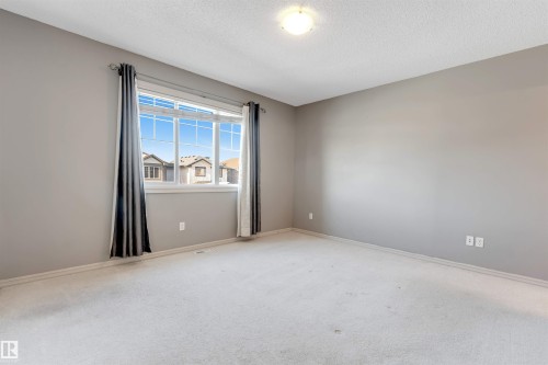 Empty room featuring light carpet and a textured ceiling - 1157 37 Avenue, Edmonton, AB - Indoor Photo Showing Other Room