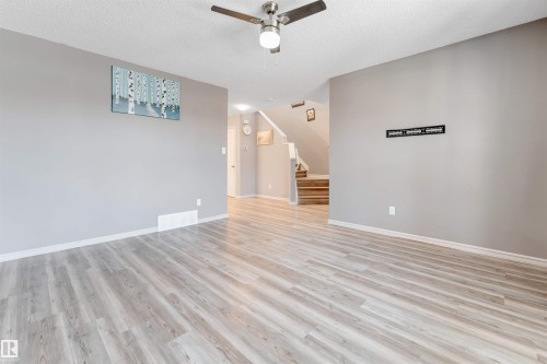 Empty room featuring ceiling fan, a textured ceiling, and light wood-style floors - 1157 37 Avenue, Edmonton, AB - Indoor Photo Showing Other Room