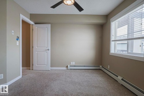 Room featuring carpeted flooring, a ceiling fan with integrated lighting, and a window with blinds - 313 1510 Watt Drive, Edmonton, AB - Indoor Photo Showing Other Room