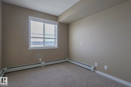 This room features a window with blinds, light-colored walls, and carpeting - 313 1510 Watt Drive, Edmonton, AB - Indoor Photo Showing Other Room