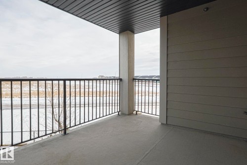The property features a balcony with a concrete floor, dark metal railings, and a solid overhead covering - 313 1510 Watt Drive, Edmonton, AB - Outdoor With Balcony With Exterior