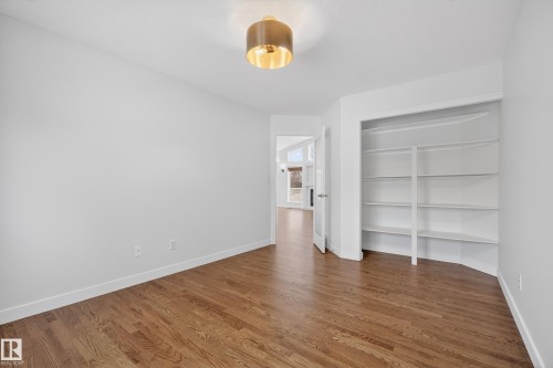 Unfurnished bedroom featuring dark wood-style flooring and a closet - 19 Country Lane, Stony Plain, AB - Indoor Photo Showing Other Room