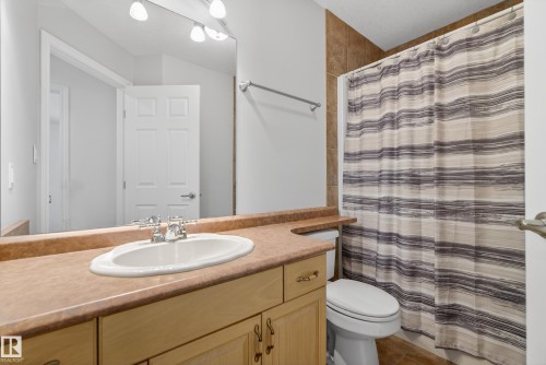Full bathroom with a shower with shower curtain, vanity, and tile patterned floors - 19 Country Lane, Stony Plain, AB - Indoor Photo Showing Bathroom