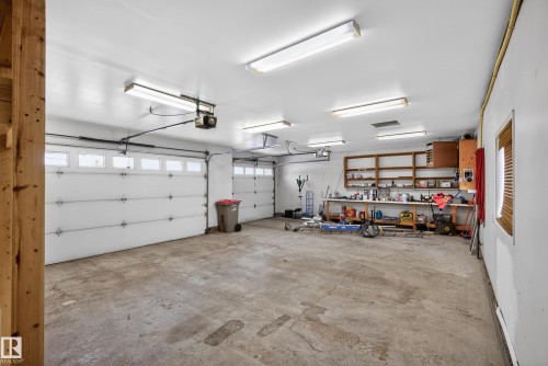 Garage with a heating unit, a garage door opener, and a workshop area - 19 Country Lane, Stony Plain, AB - Indoor Photo Showing Garage