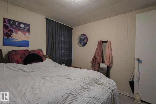 Bedroom featuring carpet floors and wood walls - 4906 48 Street, Thorsby, AB - Indoor Photo Showing Bedroom