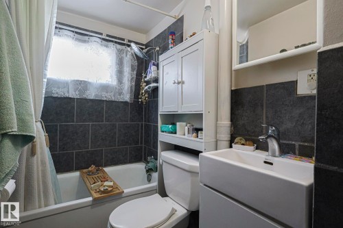 Bathroom featuring vanity, shower / bath combo, and tasteful backsplash - 4906 48 Street, Thorsby, AB - Indoor Photo Showing Bathroom