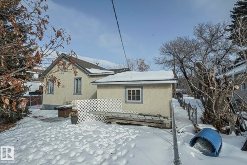 Snow covered rear of property featuring stucco siding and a wooden deck - 4906 48 Street, Thorsby, AB - Outdoor