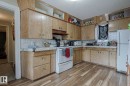 Kitchen featuring white appliances, light countertops, light wood-style floors, backsplash, and open shelves - 4906 48 Street, Thorsby, AB  - Indoor Photo Showing Kitchen 