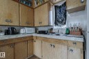 Kitchen featuring tasteful backsplash, wood finish cabinetry, white microwave, and freestanding refrigerator - 4906 48 Street, Thorsby, AB  - Indoor Photo Showing Kitchen With Double Sink 