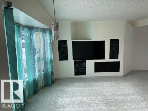 Unfurnished living room featuring light carpet and a textured ceiling - 11 Campbell, Stony Plain, AB - Indoor Photo Showing Other Room