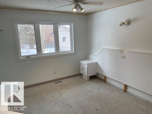 Unfurnished bedroom with light carpet, a textured ceiling, and ceiling fan - 11 Campbell, Stony Plain, AB - Indoor