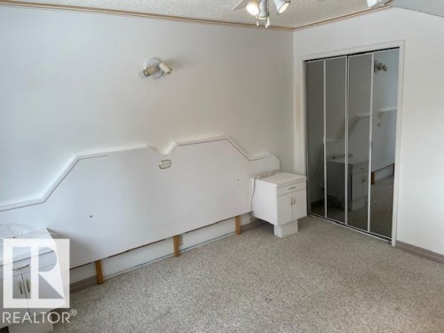 Unfurnished bedroom with light carpet, a closet, ceiling fan, and a textured ceiling - 11 Campbell, Stony Plain, AB - Indoor