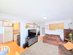 Living room featuring light wood-style floors, a ceiling fan, and a textured ceiling - 