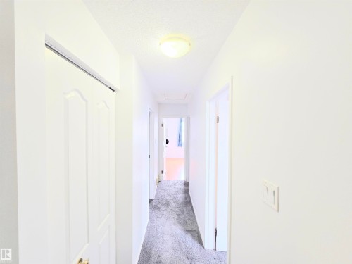 Hall featuring light colored carpet and a textured ceiling - 80 Amberly Crest, Edmonton, AB - Indoor Photo Showing Other Room
