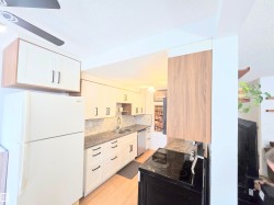 Kitchen with freestanding refrigerator, black range with electric stovetop, a textured ceiling, white cabinets, and a ceiling fan - 