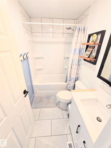 Full bathroom featuring vanity, shower / bath combo, and light tile patterned floors - 80 Amberly Crest, Edmonton, AB - Indoor Photo Showing Bathroom