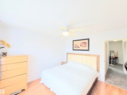 Bedroom with light wood finished floors and a ceiling fan - 