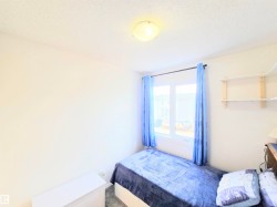 Bedroom featuring a textured ceiling and carpet - 