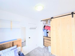 Bedroom with light carpet, a barn door, and a closet - 